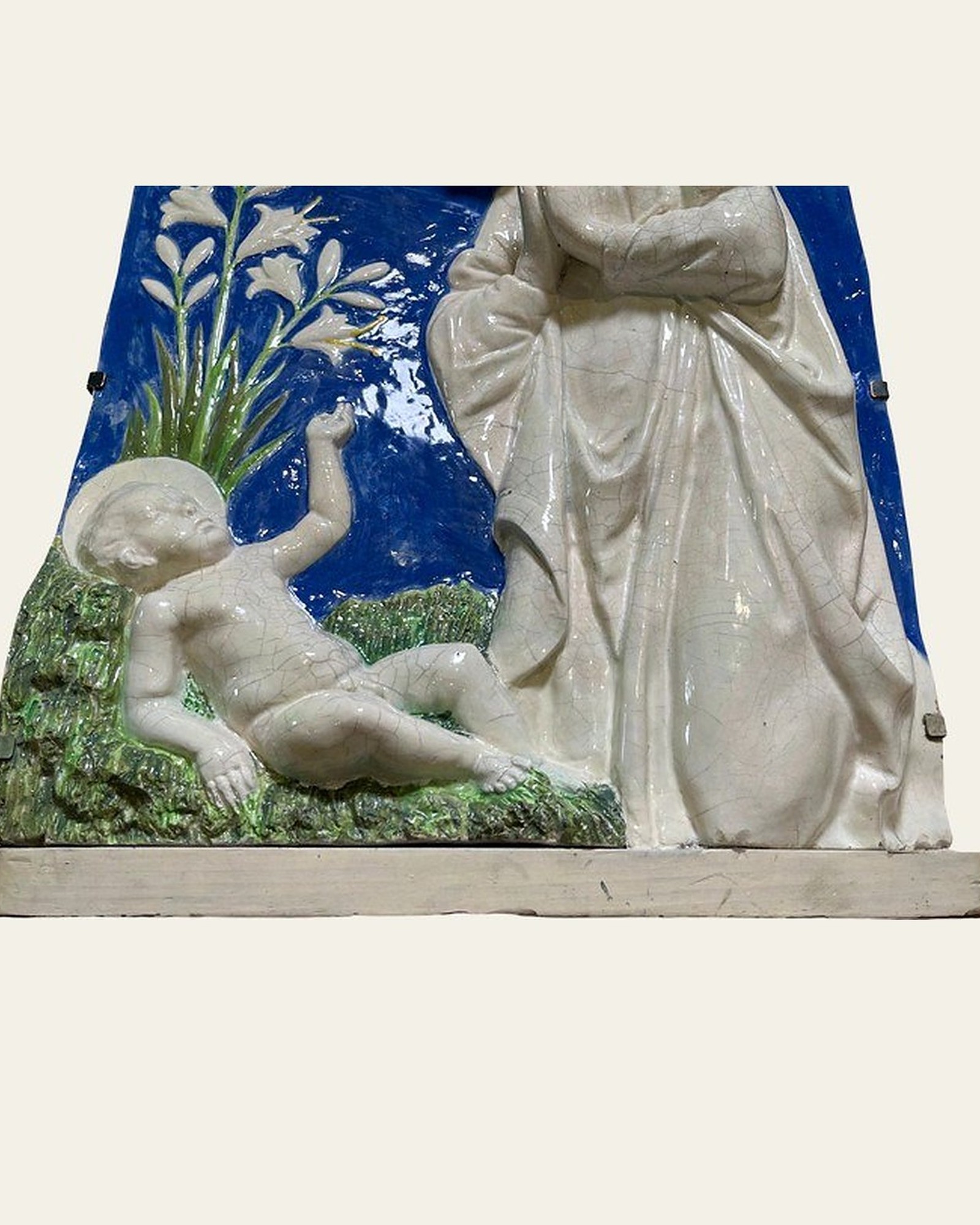 Detail of the Della Robbia-style plaque after restoration, with retouched fills.
