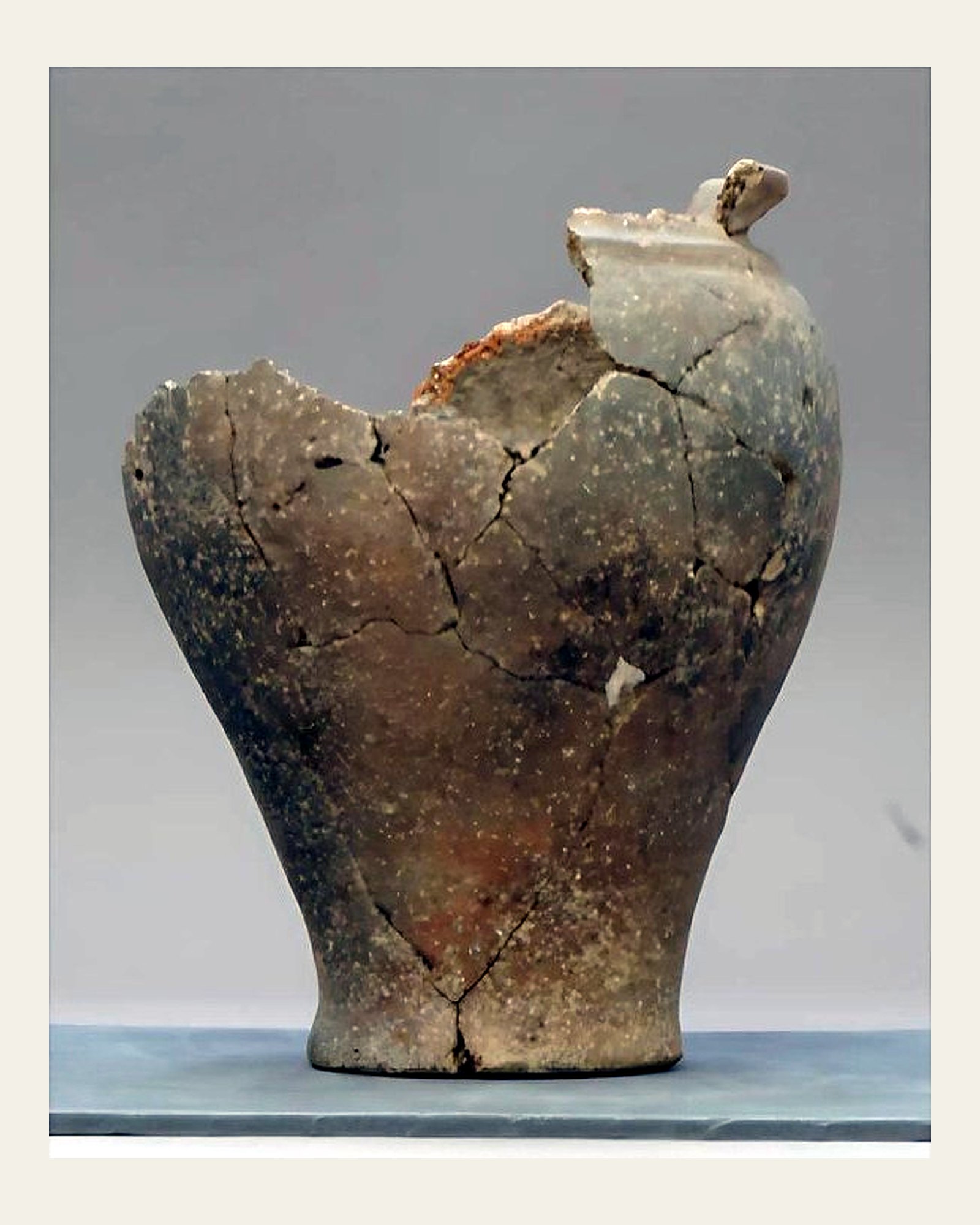 Excavated earthenware vessel before conservation treatment, fragmented with failing earlier repairs.